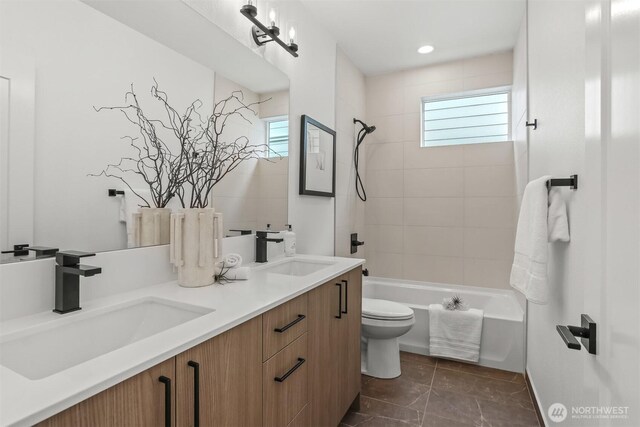 bathroom featuring toilet, a wealth of natural light, and a sink