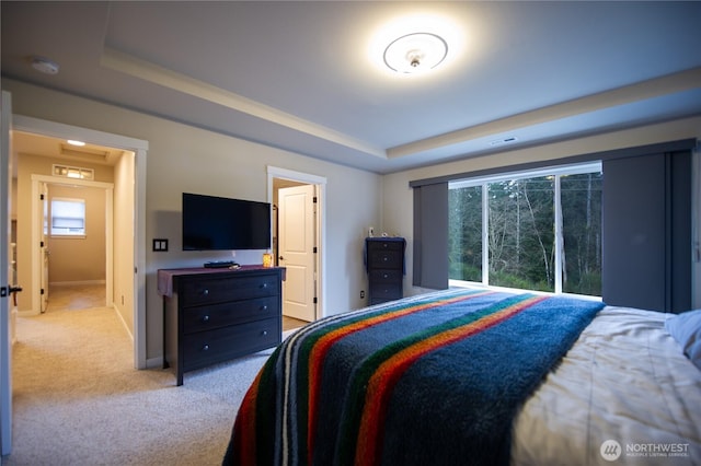 bedroom with baseboards, a raised ceiling, visible vents, and carpet flooring