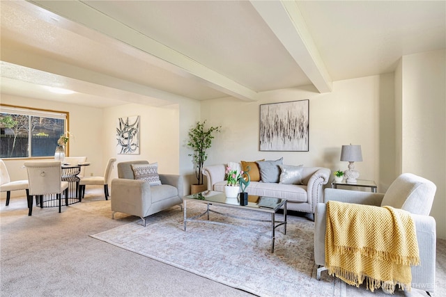 living area featuring beam ceiling and carpet