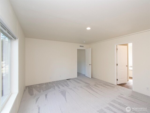 unfurnished room with recessed lighting, visible vents, and light colored carpet