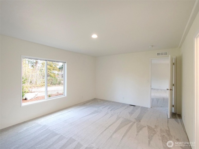 unfurnished room with recessed lighting, visible vents, and light colored carpet