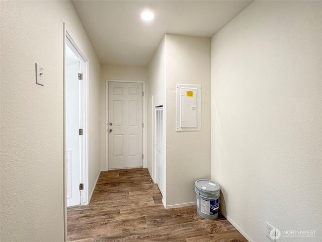 hallway with electric panel and wood finished floors