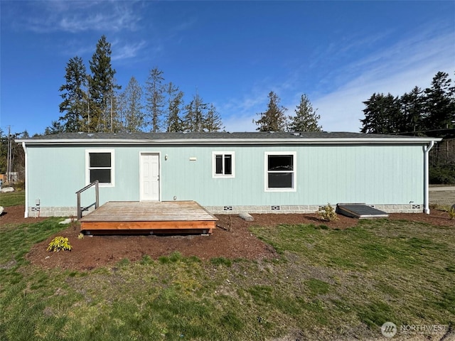 back of house featuring a deck, a lawn, and crawl space