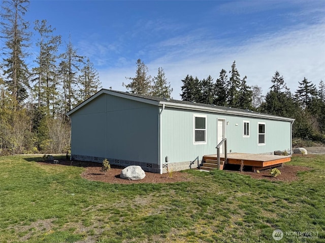 back of house with crawl space, a lawn, and a deck