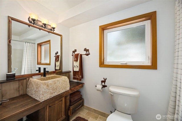 full bath featuring curtained shower, toilet, vanity, and baseboards