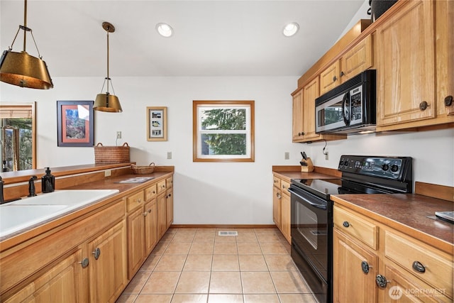 kitchen featuring a sink, stainless steel microwave, black / electric stove, light tile patterned floors, and baseboards