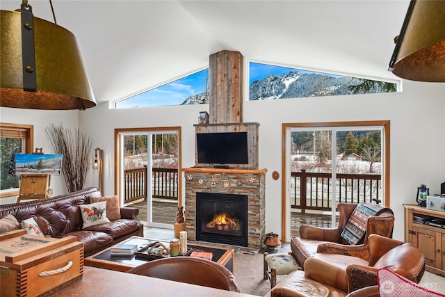 carpeted living room with high vaulted ceiling and a stone fireplace