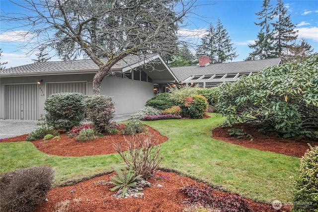 view of yard featuring driveway and an attached garage