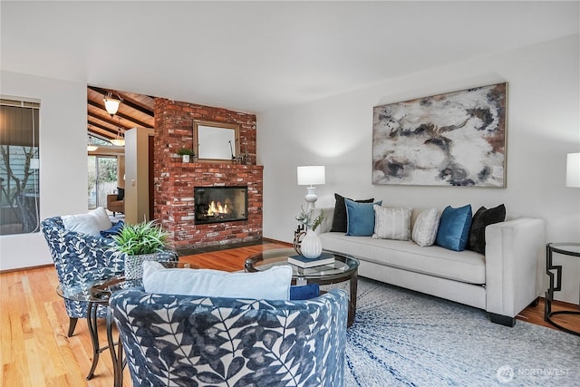 living room featuring lofted ceiling, wood finished floors, and a fireplace