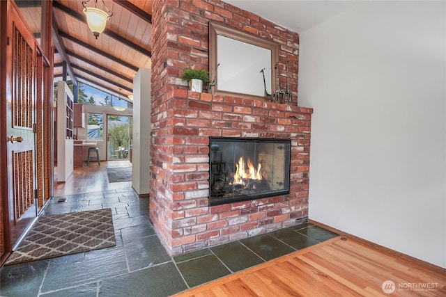 interior space with beam ceiling, a brick fireplace, and wood ceiling