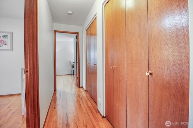 hallway with light wood-style floors and baseboards