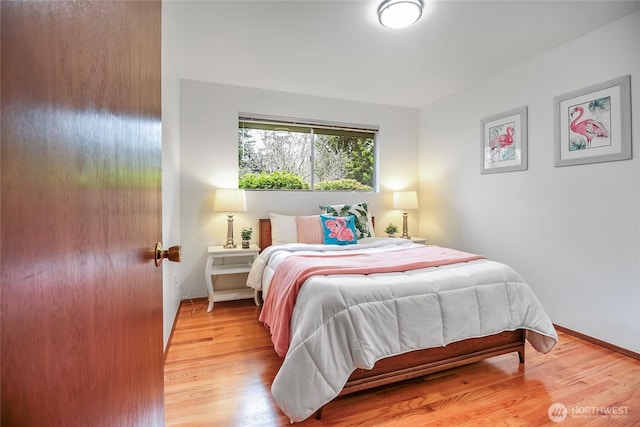 bedroom with light wood-style flooring and baseboards