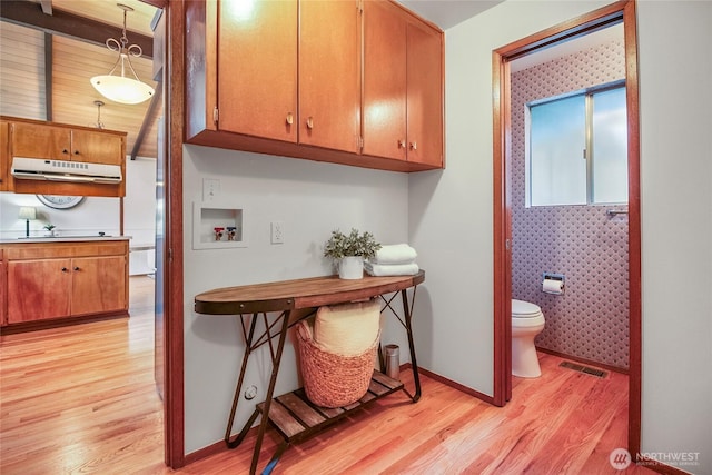 interior space with toilet, wood finished floors, visible vents, and baseboards