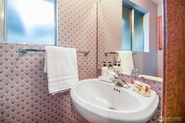 bathroom featuring wallpapered walls and a sink