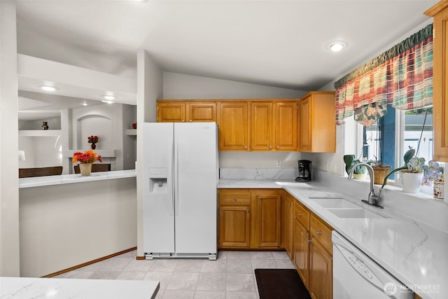 kitchen featuring light stone counters, white appliances, lofted ceiling, and a sink