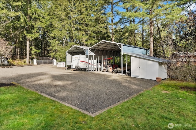 view of front facade featuring a detached carport, a front lawn, and aphalt driveway