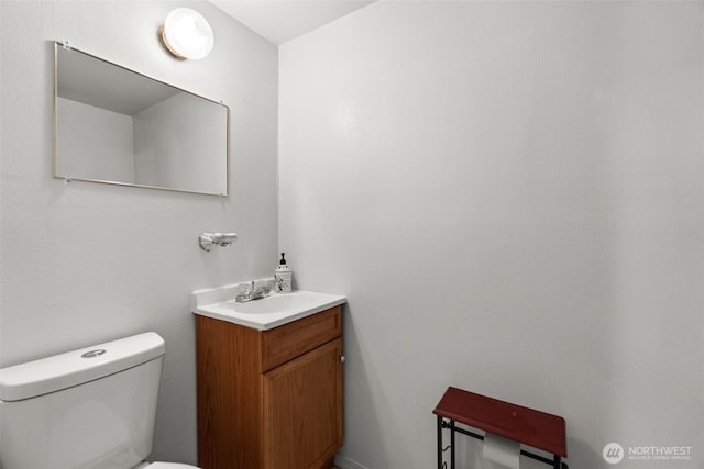 half bath featuring vanity and toilet