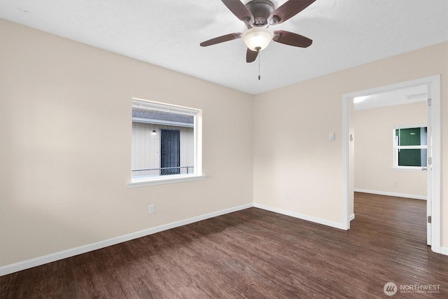 empty room with ceiling fan, baseboards, and wood finished floors