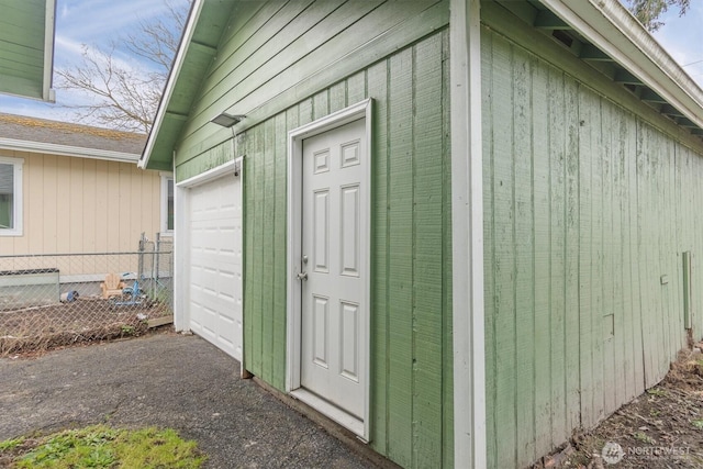 entrance to property with a garage and fence