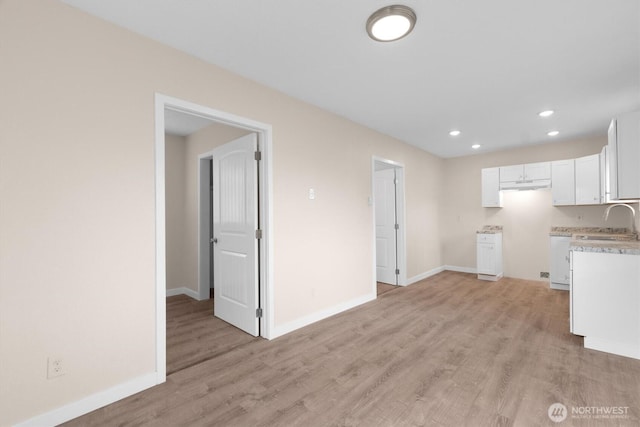 unfurnished living room with light wood finished floors, recessed lighting, and baseboards