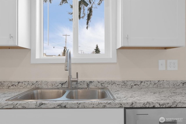 interior details featuring white cabinets and a sink