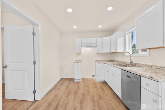 kitchen featuring under cabinet range hood, light wood-style flooring, stainless steel dishwasher, white cabinets, and a sink