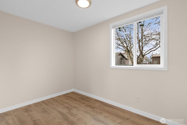 unfurnished room featuring baseboards and wood finished floors