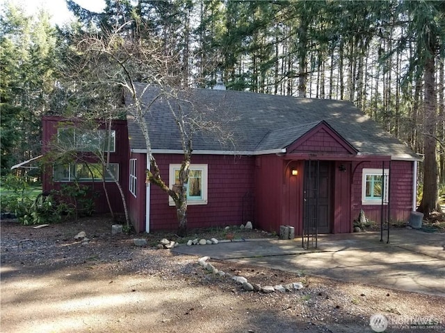 exterior space featuring a patio area and a shingled roof