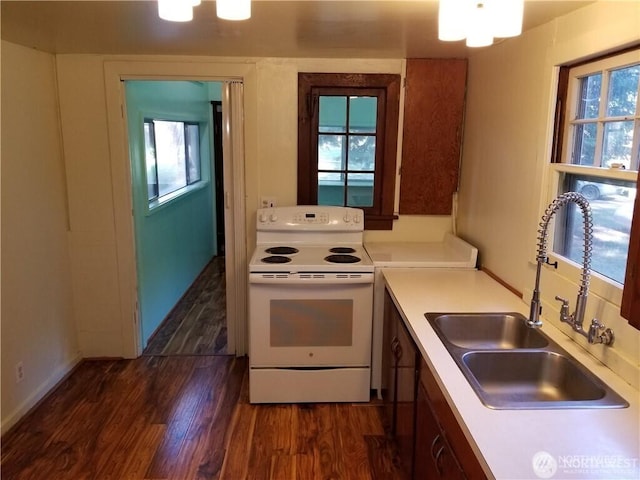 kitchen with baseboards, light countertops, dark wood-style floors, white electric range, and a sink