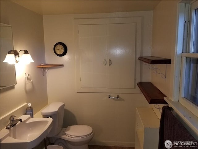 half bath featuring toilet and a sink