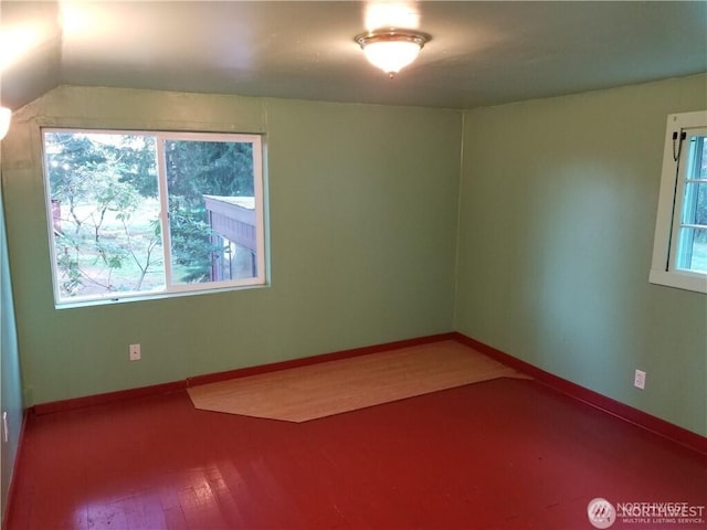 spare room featuring baseboards and wood finished floors