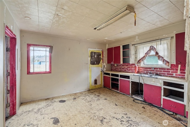 kitchen featuring open shelves, red cabinets, and light countertops