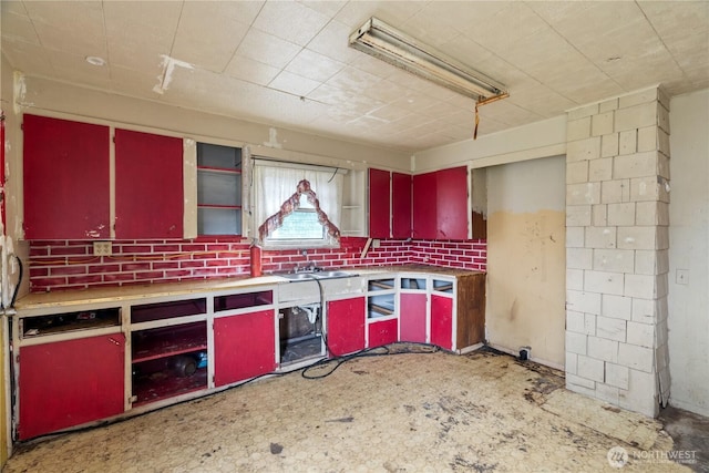 kitchen with red cabinetry, yellow cabinetry, and a sink