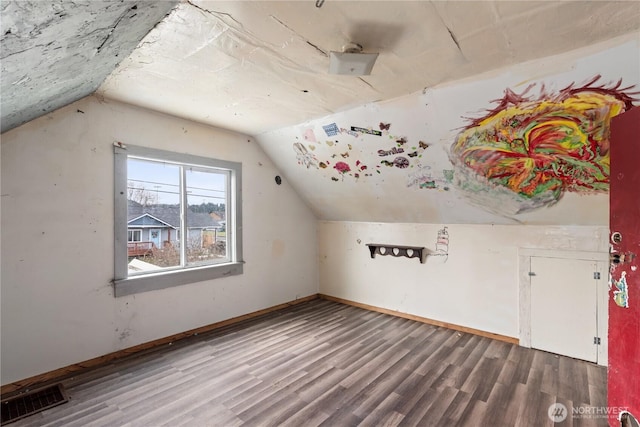 bonus room with visible vents, lofted ceiling, baseboards, and wood finished floors