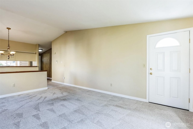 entrance foyer with lofted ceiling, an inviting chandelier, baseboards, and carpet floors