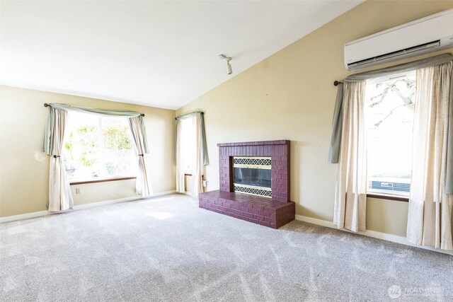 unfurnished living room with baseboards, lofted ceiling, a fireplace, a wall mounted air conditioner, and carpet flooring