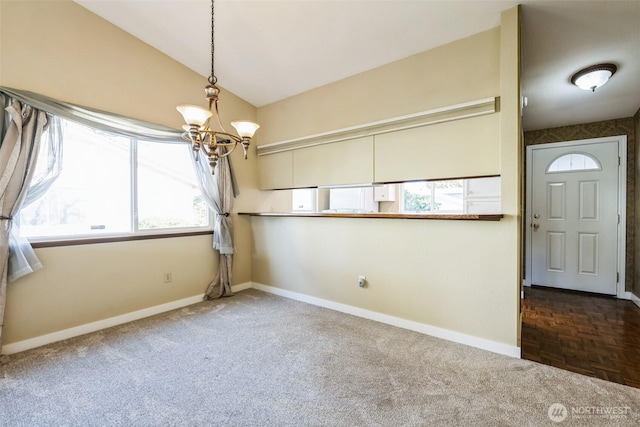 interior space featuring an inviting chandelier, baseboards, and lofted ceiling