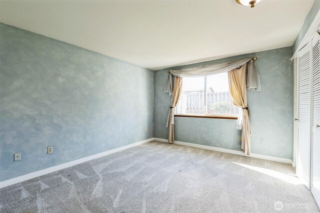 carpeted spare room with baseboards