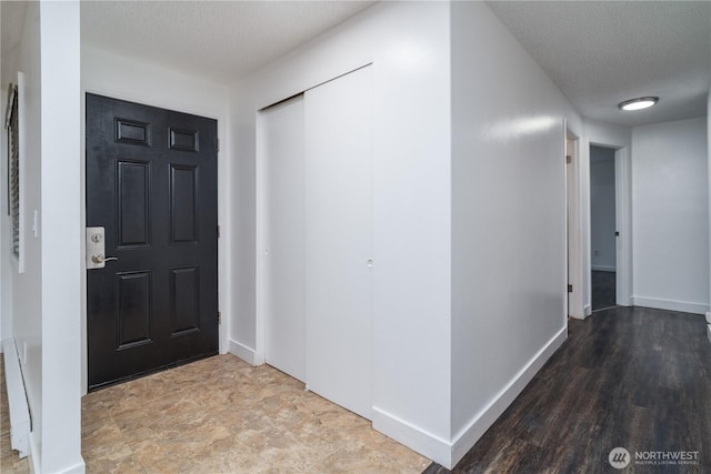 entrance foyer featuring a textured ceiling and baseboards