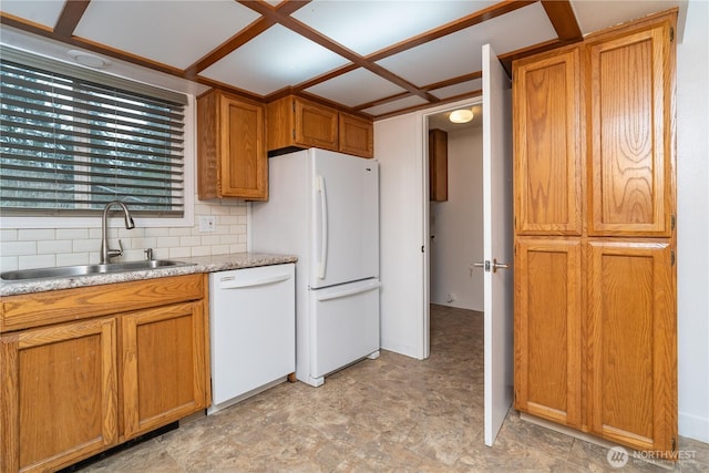 kitchen featuring light countertops, decorative backsplash, brown cabinets, white appliances, and a sink