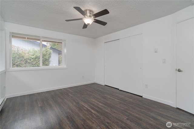 unfurnished bedroom with a ceiling fan, dark wood-style floors, baseboards, and a textured ceiling