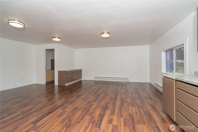 unfurnished room featuring dark wood finished floors, baseboards, and a baseboard radiator