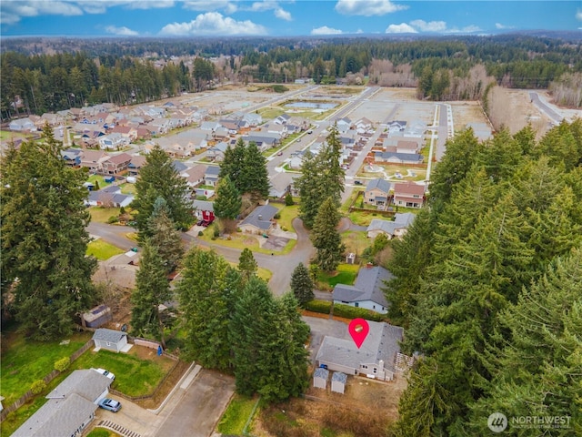 drone / aerial view featuring a forest view and a residential view