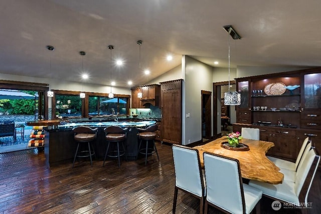 dining room featuring dark wood-type flooring and lofted ceiling