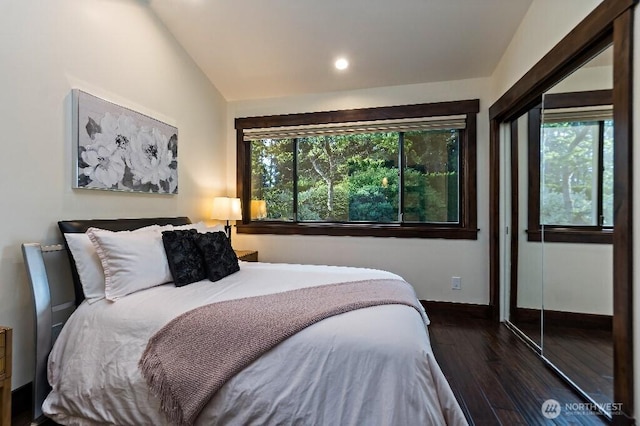 bedroom featuring vaulted ceiling, wood finished floors, and baseboards