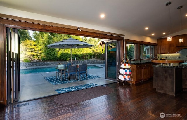 interior space featuring dark wood finished floors, lofted ceiling, and a wealth of natural light