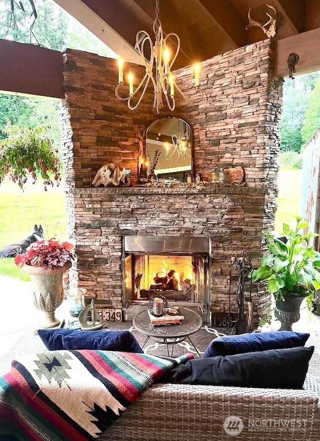 living room with beamed ceiling and an outdoor stone fireplace