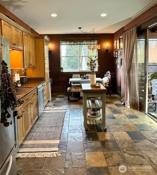 kitchen with stone tile flooring, recessed lighting, stainless steel appliances, and dark countertops