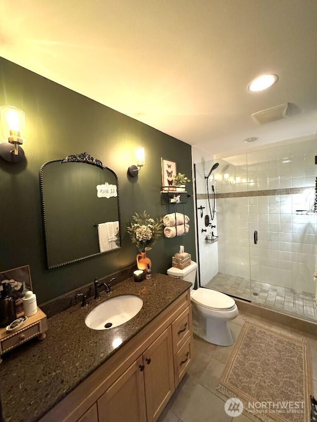 bathroom featuring tile patterned flooring, a stall shower, toilet, and vanity