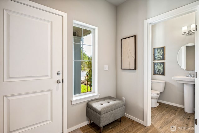 doorway to outside featuring baseboards and wood finished floors